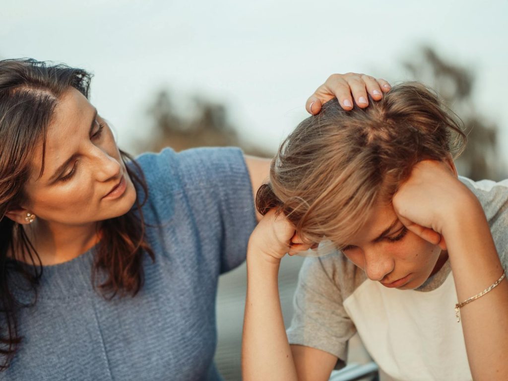 A mother offers support to her discouraged teenager son, portraying love and understanding.